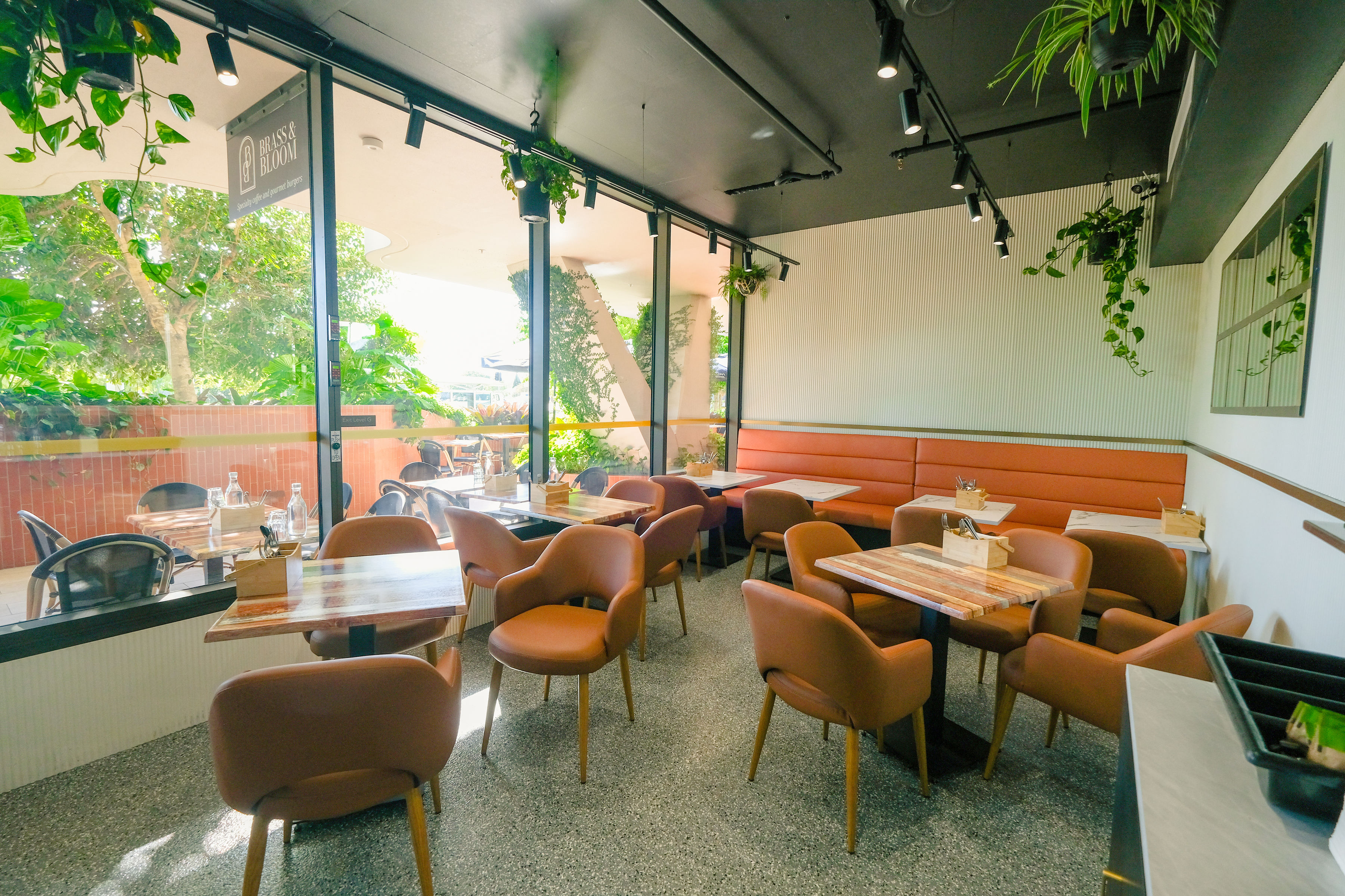 Bright cafe interior with botanical plants and brass fixtures